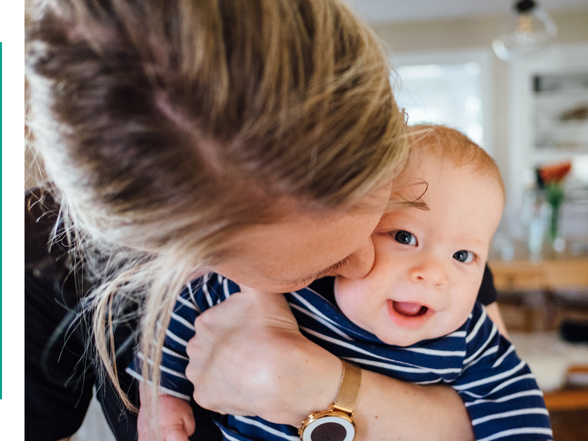 mother kissing baby on cheek